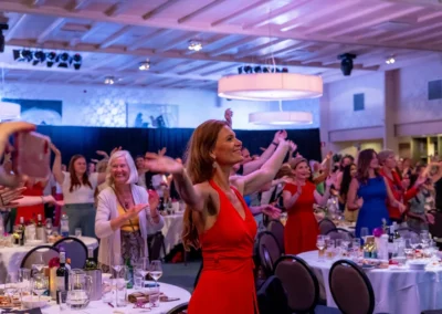 Mensen genieten en dansen tijdens een feestelijk evenement in een sfeervolle zaal, georganiseerd door Willem de Boer in De Koningshof.