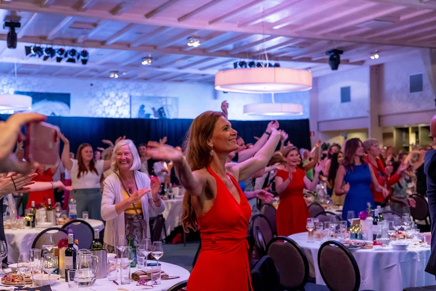 Mensen genieten en dansen tijdens een feestelijk evenement in een sfeervolle zaal, georganiseerd door Willem de Boer in De Koningshof.