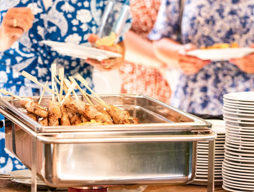 Gegrilde kipsatés op een buffetstation.