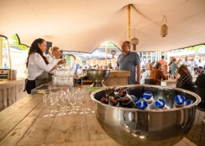 Een serveerster schenkt drankjes in tijdens een levendig buitenevenement